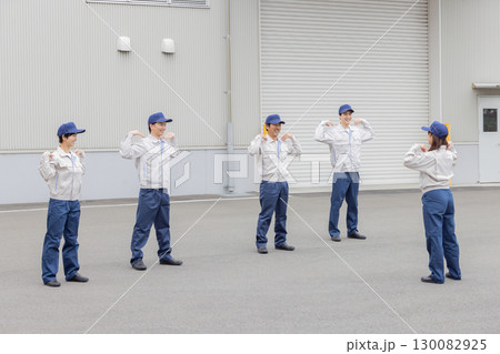 工場の前で体操する作業員グループ 130082925
