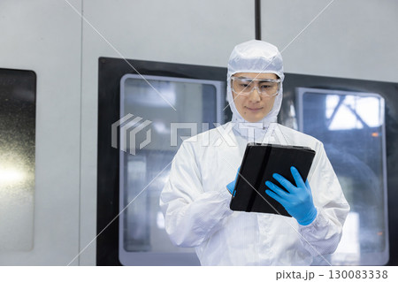 工場でタブレットPCを使う防護服を着た作業員 工場でタブレットPCを使う防護服を着た作業員 130083338