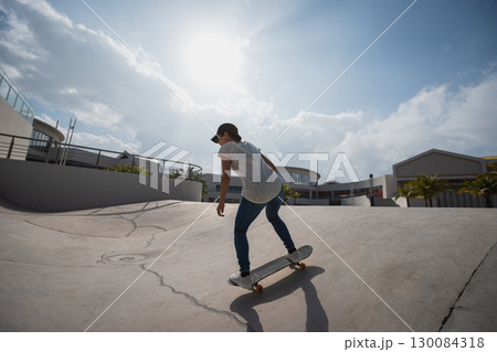 Skateboarder skateboarding at skatepark in city 130084318