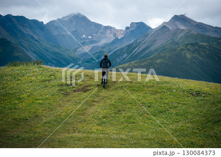 People riding mountain bike on flowering grassland mountain trail People riding mountain bike on flowering grassland mountain trail 130084373