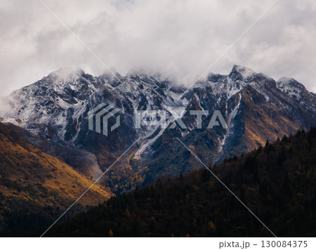 Aerial view of beautiful autumn forest landscape and snow capped mountains Aerial view of beautiful autumn forest landscape and snow capped mountains 130084375