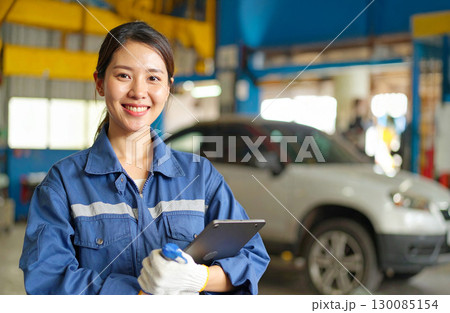 笑顔の女性整備士と車の整備現場 130085154