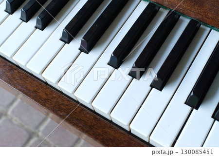 A close-up shot of piano keys, highlighting the contrast between black and white. 130085451
