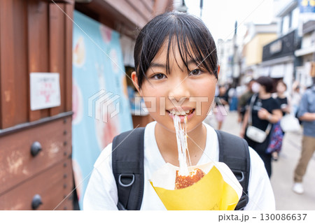 鎌倉観光をしながら食べ歩きをする10代の女性 130086637