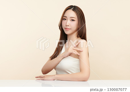 A beautiful young Asian woman with clean, fresh skin against a beige background. Skincare, facial treatment, cosmetology, beauty, and spa. An elegant portrait of an Asian woman. A beautiful young Asian woman with clean, fresh skin against a beige background. Skincare, facial treatment, cosmetology, beauty, and spa. An elegant portrait of an Asian woman. 130087077
