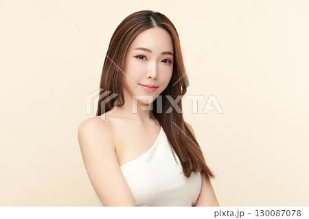 A beautiful young Asian woman with clean, fresh skin against a beige background. Skincare, facial treatment, cosmetology, beauty, and spa. An elegant portrait of an Asian woman. A beautiful young Asian woman with clean, fresh skin against a beige background. Skincare, facial treatment, cosmetology, beauty, and spa. An elegant portrait of an Asian woman. 130087078