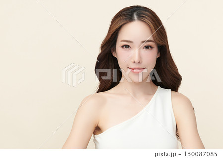A beautiful young Asian woman with clean, fresh skin against a beige background. Skincare, facial treatment, cosmetology, beauty, and spa. An elegant portrait of an Asian woman. A beautiful young Asian woman with clean, fresh skin against a beige background. Skincare, facial treatment, cosmetology, beauty, and spa. An elegant portrait of an Asian woman. 130087085