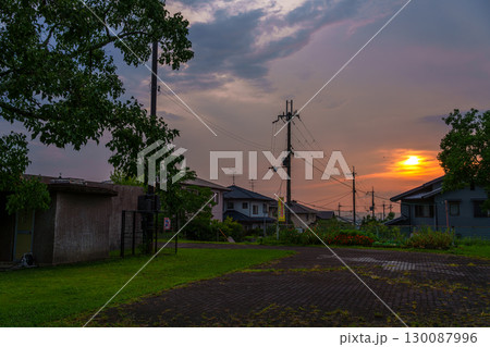晩夏 雲間から覗く夕焼け空 公園の奥に広がる街並みを夕焼け色に包んで行く黄金色の夕日 晩夏 雲間から覗く夕焼け空 公園の奥に広がる街並みを夕焼け色に包んで行く黄金色の夕日 130087996