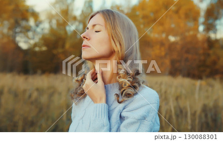 Sick exhausted woman suffering from acute sore in throat flu, touches her neck with hand in autumn 130088301