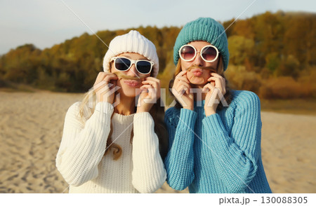 Happy cheerful women friends having fun, funny girlfriends together outdoors in autumn park Happy cheerful women friends having fun, funny girlfriends together outdoors in autumn park 130088305