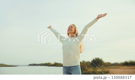 Happy joyful woman on the beach, enjoying landscape, warm weather, standing on sea coast Happy joyful woman on the beach, enjoying landscape, warm weather, standing on sea coast 130088317