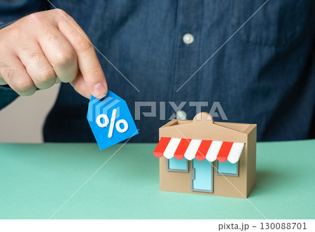Man holding a discount coupon near a store. Sale and discounts. Marketing, attracting customers with promotions and boosting retail demand 130088701