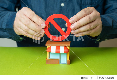 The men hold a NO sign above the store. Business closure, legal restrictions, retail ban, failed investment, economic pressure The men hold a NO sign above the store. Business closure, legal restrictions, retail ban, failed investment, economic pressure 130088836