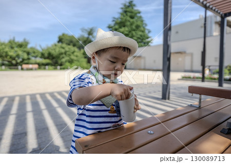公園のベンチで水筒を開ける男の子 130089713