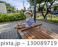 公園のベンチに座っている子供 130089719