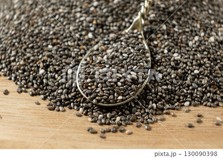 Chia seeds in a spoon on a wooden background, close-up. Chia seeds in a spoon on a wooden background, close-up. 130090398