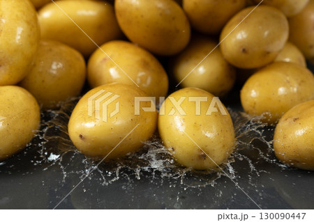 Whole fresh unpeeled potatoes in a splash of water. Whole fresh unpeeled potatoes in a splash of water. 130090447