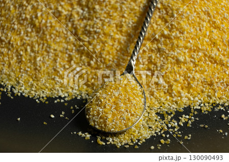 Raw Yellow Corn Grits in a Spoon Raw Yellow Corn Grits in a Spoon 130090493