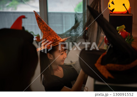 Halloween Spirit. A girl decorates for Halloween with a smile and festive accessories. Halloween Spirit. A girl decorates for Halloween with a smile and festive accessories. 130091552