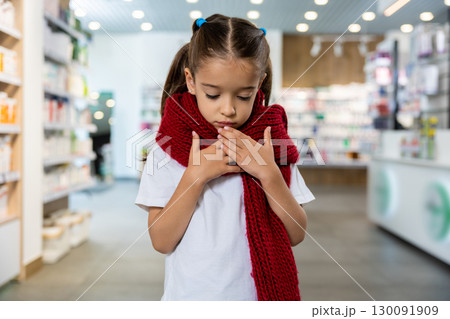 Little cute girl with a red scarf around her neck suffering from a sore throat Little cute girl with a red scarf around her neck suffering from a sore throat 130091909