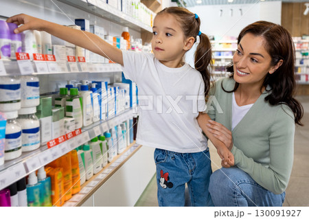 Mom and daughter in the pharmacy choosing medicines 130091927