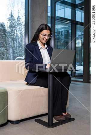 Young woman sitting in the office and working on laptop Young woman sitting in the office and working on laptop 130091966