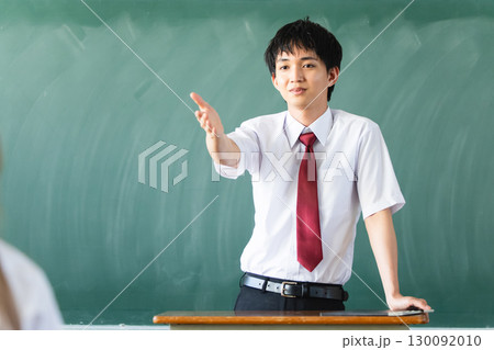黒板の前で指差しする男性 黒板の前で指差しする男性 130092010