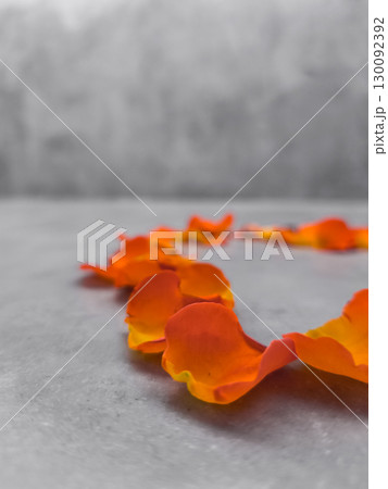 Orange flower petals forming heart shape on marble surface 130092392