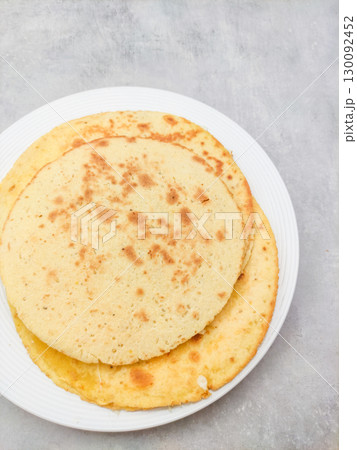 Socca pancakes resting on white plate on gray surface 130092452