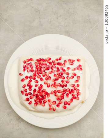 Delicious tres leches milk cake with pomegranate seeds on white plate for birthday 130092455