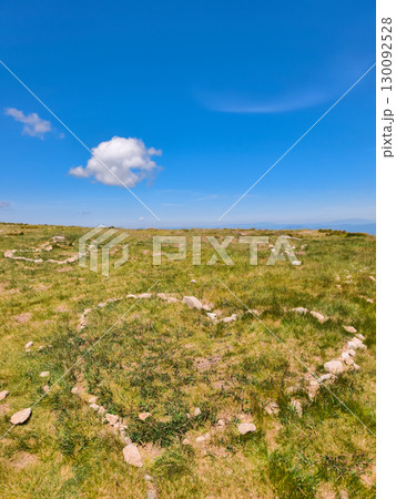 Heart shaped stone arrangements on a grassy hillside under a blue sky Heart shaped stone arrangements on a grassy hillside under a blue sky 130092528