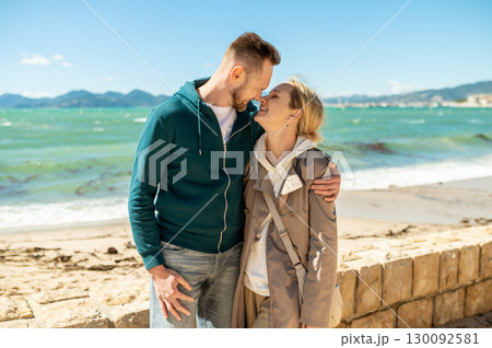 Couple embracing intimately on sunny beach with ocean view Couple embracing intimately on sunny beach with ocean view 130092581