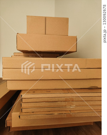Stacked cardboard boxes in a room corner, storage and organization concept 130092678