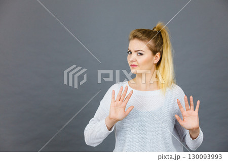 Woman deny something showing stop gesture with hands Woman deny something showing stop gesture with hands 130093993