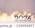 Metal numbers 2026 on a white table with Christmas trees and bokeh lights. Happy New Year 2026 is coming concept. 130094897