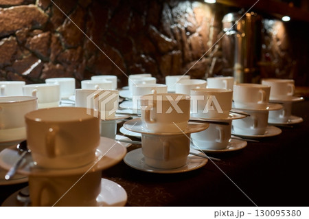 Neatly stacked white coffee cups for elegant events or catering, making a stylish presentation 130095380