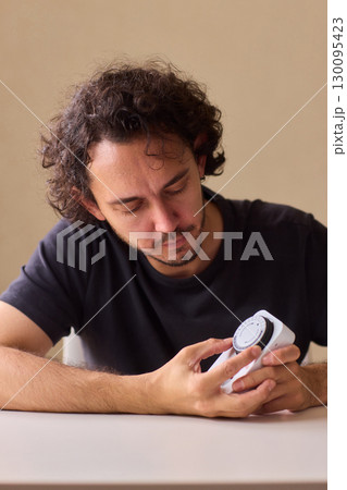 Hands Carefully Connecting a Plug to a Power Strip for Convenient Charging Needs 130095423