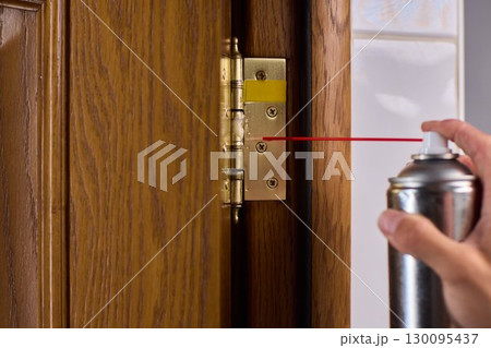 Lubricating a door hinge is extremely essential for ensuring smooth operation in daily use Lubricating a door hinge is extremely essential for ensuring smooth operation in daily use 130095437