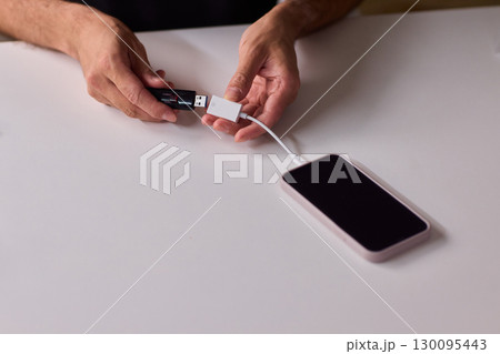 man using otg usb with her mobile phone to copy photos 130095443