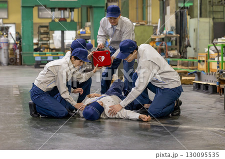 工場で倒れた作業員をAEDで救護するグループ 130095535