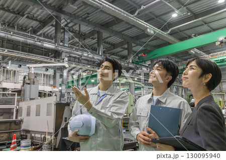 工場を視察する女性ビジネスパーソンと男性作業員 130095940