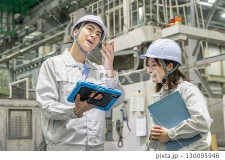 タブレットを持って工場機械を点検する男女作業員 タブレットを持って工場機械を点検する男女作業員 130095946