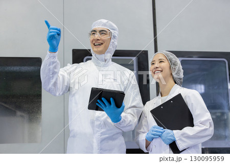 工場でタブレットPCを使う防護服を着た作業員 工場でタブレットPCを使う防護服を着た作業員 130095959
