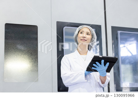 工場でタブレットを持って仕事をする作業員 130095966