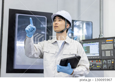 工場の操作盤の前で働く男性作業員 130095967
