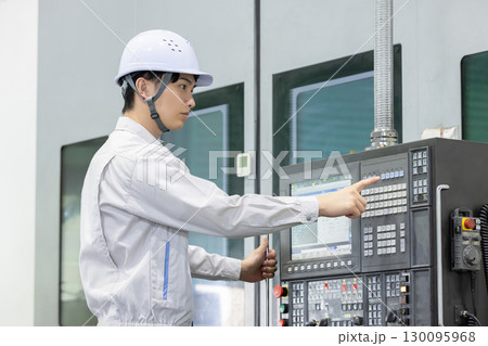 工場の操作盤の前で働く男性作業員 130095968