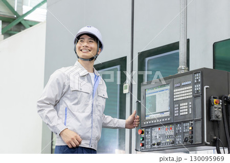 工場の操作盤の前で働く男性作業員 130095969