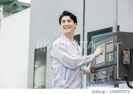 工場の操作盤の前で働く男性作業員 130095972