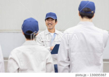 屋外でミーティングする作業員グループ 130095987