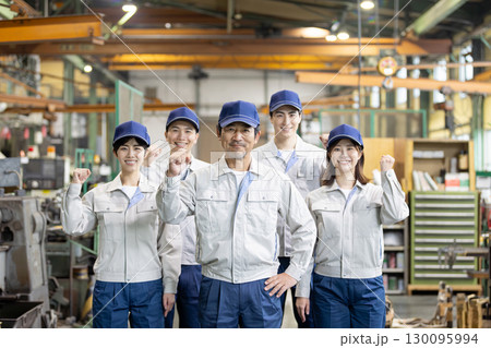 工場の中に立つ作業員グループ 130095994